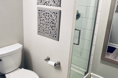 Small trendy 3/4 white tile and subway tile laminate floor, multicolored floor and single-sink bathroom photo in Other with shaker cabinets, gray cabinets, a two-piece toilet, gray walls, an undermount sink, marble countertops, yellow countertops and a freestanding vanity