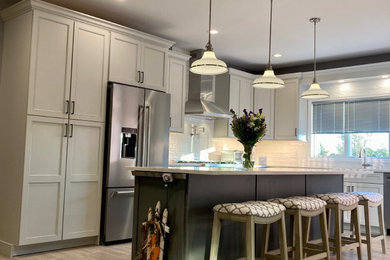 Eat-in kitchen - mid-sized transitional l-shaped porcelain tile and beige floor eat-in kitchen idea in New York with an undermount sink, shaker cabinets, gray cabinets, quartz countertops, white backsplash, ceramic backsplash, stainless steel appliances, an island and white countertops