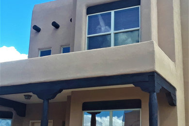 Mid-sized southwestern brown two-story stucco exterior home idea in Albuquerque with a green roof