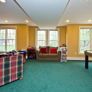 This is an example of an expansive traditional walk-out basement in Boston with yellow walls, carpet and turquoise floors.