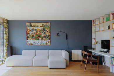 Ejemplo de biblioteca en casa abierta escandinava de tamaño medio sin chimenea y televisor con paredes azules y suelo de madera en tonos medios