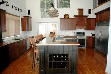 Large mountain style medium tone wood floor and brown floor kitchen photo in Toronto with shaker cabinets, brown cabinets, stainless steel appliances, an island and beige countertops