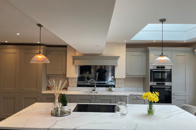 Medium sized traditional single-wall kitchen/diner in Other with a double-bowl sink, recessed-panel cabinets, beige cabinets, quartz worktops, white splashback, stainless steel appliances, an island, white worktops and a coffered ceiling.
