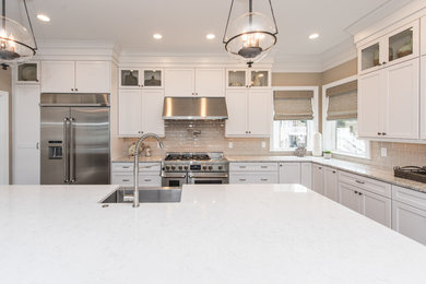 Large elegant l-shaped medium tone wood floor and brown floor eat-in kitchen photo in DC Metro with a farmhouse sink, shaker cabinets, white cabinets, quartz countertops, beige backsplash, porcelain backsplash, stainless steel appliances, an island and gray countertops