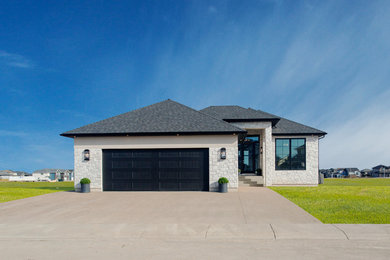 Mid-sized transitional white one-story stone house exterior photo in Other with a hip roof and a shingle roof