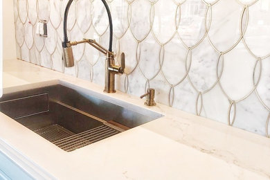 Example of a small eclectic single-wall dark wood floor and brown floor eat-in kitchen design in Boston with an undermount sink, raised-panel cabinets, white cabinets, marble countertops, white backsplash, marble backsplash, stainless steel appliances, an island and white countertops
