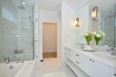 Inspiration for a large contemporary master white tile ceramic tile bathroom remodel in Other with flat-panel cabinets, white cabinets, an undermount sink, quartzite countertops and a hinged shower door