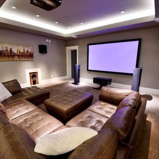 Inspiration for a large traditional open plan home cinema in Raleigh with carpet, grey walls, a projector screen and beige floors.