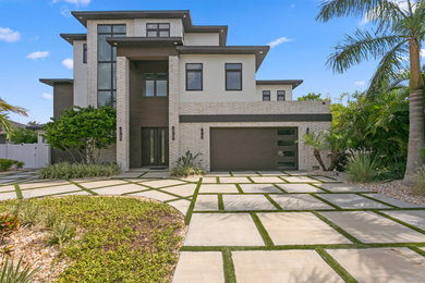 This is an example of a large contemporary full sun front yard concrete paver driveway in Tampa for summer.