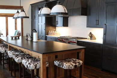 Eat-in kitchen - huge farmhouse dark wood floor eat-in kitchen idea in DC Metro with a farmhouse sink, shaker cabinets, black cabinets, granite countertops, white backsplash, ceramic backsplash, stainless steel appliances and an island
