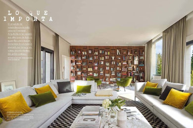 Ispirazione per un soggiorno design stile loft con libreria e camino bifacciale