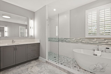 Mid-sized minimalist master white tile and porcelain tile marble floor, white floor and double-sink bathroom photo in Tampa with shaker cabinets, gray cabinets, gray walls, an undermount sink, quartz countertops, white countertops, a niche and a built-in vanity