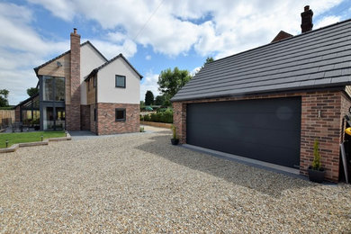 This is an example of a large and multi-coloured modern brick detached house in Other with three floors, a pitched roof and a tiled roof.