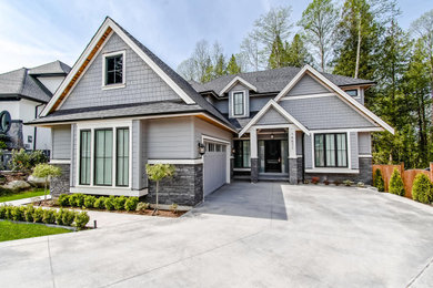 Example of a large arts and crafts gray three-story concrete fiberboard and shingle exterior home design in Vancouver with a shingle roof and a gray roof