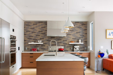 Open concept kitchen - contemporary l-shaped light wood floor and beige floor open concept kitchen idea in San Francisco with an undermount sink, flat-panel cabinets, medium tone wood cabinets, multicolored backsplash, stainless steel appliances, an island and white countertops