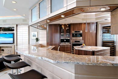 Trendy u-shaped beige floor enclosed kitchen photo in Miami with flat-panel cabinets, medium tone wood cabinets, granite countertops, stainless steel appliances and an island
