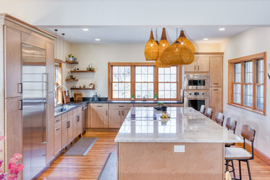 Large transitional medium tone wood floor and beige floor kitchen photo in Other with an undermount sink, flat-panel cabinets, light wood cabinets, quartzite countertops, stainless steel appliances, two islands and black countertops