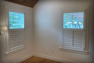 Mid-sized elegant master medium tone wood floor and brown floor bedroom photo in Other with beige walls