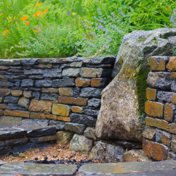 Boulder firepit in dry laid Goshen stone wall