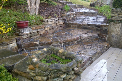 Inspiration for a mid-sized traditional stone landscaping in Other.