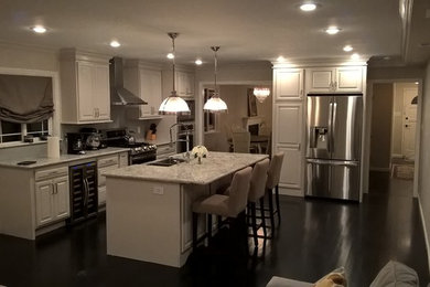 Inspiration for a modern u-shaped dark wood floor kitchen remodel in New York with a farmhouse sink, granite countertops, gray backsplash, ceramic backsplash and stainless steel appliances