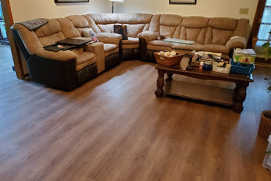 Example of a large classic open concept vinyl floor, brown floor and vaulted ceiling family room design in Charlotte with white walls, no fireplace and no tv