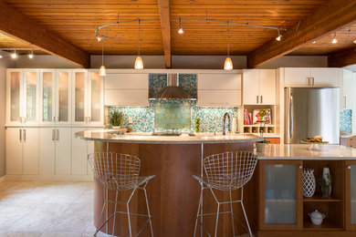 Eat-in kitchen - large tropical galley porcelain tile eat-in kitchen idea in Boston with a double-bowl sink, flat-panel cabinets, white cabinets, quartz countertops, blue backsplash, glass tile backsplash, stainless steel appliances and an island