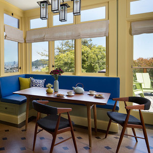 Cette photo montre une petite salle à manger rétro avec un mur jaune, un sol en vinyl et un sol marron.