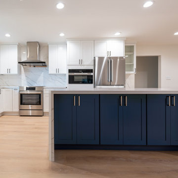 Modern White Shaker Kitchen with Navy Blue Island and Waterfall Quartz Counterto