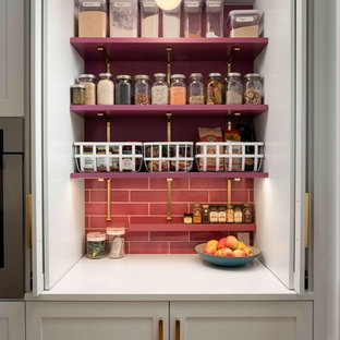 Zweizeilige, Mittelgroße Klassische Küche mit Vorratsschrank, Unterbauwaschbecken, Schrankfronten mit vertiefter Füllung, weißen Schränken, Quarzit-Arbeitsplatte, Küchenrückwand in Rosa, Rückwand aus Keramikfliesen, Küchengeräten aus Edelstahl, braunem Holzboden, Kücheninsel und weißer Arbeitsplatte in Portland