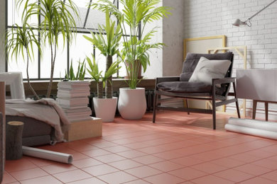 Urban porcelain tile, brick wall and red floor living room photo in Other