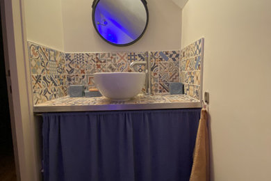 Cette photo montre un petit WC et toilettes avec un lavabo posé, un plan de toilette en bois et un plan de toilette bleu.
