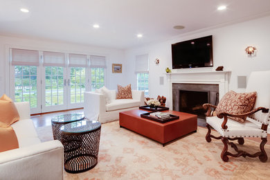 Photo of a large traditional formal enclosed living room in New York with grey walls, a standard fireplace, a stone fireplace surround, a wall-mounted tv and medium hardwood floors.