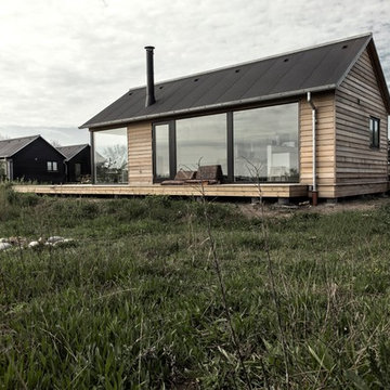 Et sort og et cedertræsbeklædt Mønhus side om side