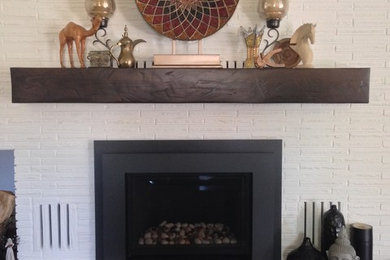 お手頃価格の中くらいなラスティックスタイルのおしゃれなLDK (白い壁、濃色無垢フローリング、標準型暖炉、レンガの暖炉まわり、茶色い床) の写真