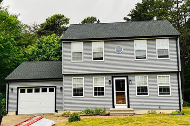 Gray vinyl and clapboard house exterior idea in Burlington with a shingle roof