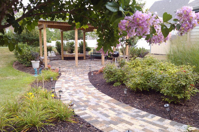 This is an example of a mid-sized traditional partial sun backyard brick landscaping in DC Metro.