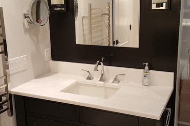 Small transitional master light wood floor and white floor bathroom photo in New York with recessed-panel cabinets, dark wood cabinets, beige walls, an undermount sink and marble countertops