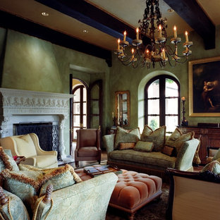 Ejemplo de salón para visitas cerrado, mediterráneo, grande, sin televisor, con paredes verdes, chimenea tradicional, suelo de madera oscura, marco de chimenea de piedra y suelo marrón