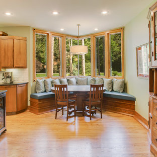 Cette image montre une grande salle à manger ouverte sur la cuisine craftsman avec un sol en bois clair et un sol marron.