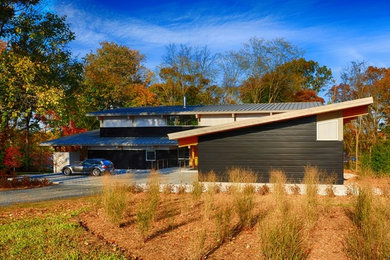 Large minimalist black three-story metal exterior home photo in Baltimore with a shed roof