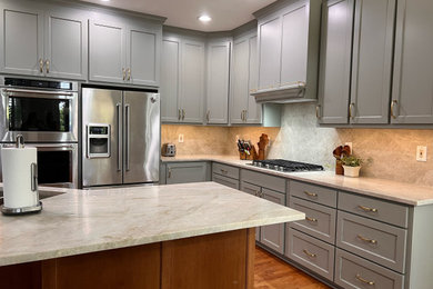 Eat-in kitchen - large transitional galley medium tone wood floor eat-in kitchen idea in Atlanta with a single-bowl sink, shaker cabinets, blue cabinets, quartzite countertops, beige backsplash, stainless steel appliances, an island and beige countertops