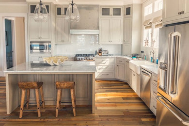 Large trendy l-shaped dark wood floor open concept kitchen photo in Miami with a farmhouse sink, beaded inset cabinets, gray cabinets, marble countertops, white backsplash, subway tile backsplash, stainless steel appliances and an island