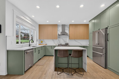 Mid-sized trendy u-shaped medium tone wood floor and brown floor eat-in kitchen photo in Portland with a single-bowl sink, shaker cabinets, green cabinets, quartz countertops, white backsplash, quartz backsplash, stainless steel appliances, an island and white countertops