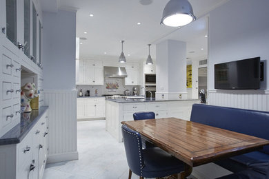 Inspiration for a contemporary galley porcelain tile eat-in kitchen remodel in New York with a double-bowl sink, flat-panel cabinets, white cabinets, granite countertops, white backsplash, subway tile backsplash, stainless steel appliances and an island