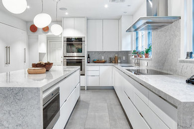 Inspiration for a large modern kitchen in New York with flat-panel cabinets, white cabinets, quartz benchtops, grey splashback, with island and grey benchtop.