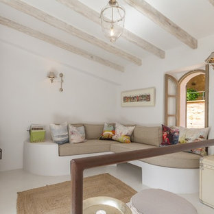 Foto de salón cerrado, mediterráneo, de tamaño medio, con paredes blancas, estufa de leña, televisor independiente y suelo blanco