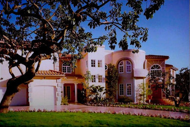 Inspiration for a huge mediterranean two-story stucco flat roof remodel in Los Angeles