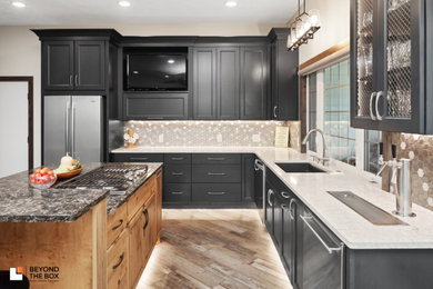 Inspiration for a large transitional l-shaped medium tone wood floor enclosed kitchen remodel in Other with an undermount sink, flat-panel cabinets, black cabinets, quartz countertops, multicolored backsplash, ceramic backsplash, stainless steel appliances, two islands and beige countertops