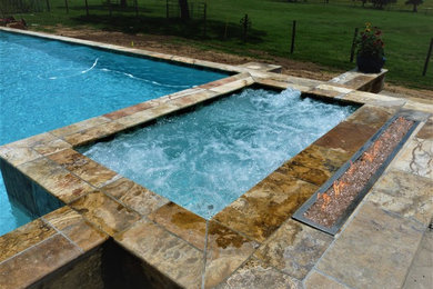 Inspiration for a large mediterranean backyard stone and rectangular hot tub remodel in Houston